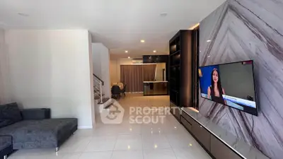 Spacious modern living room with sleek TV setup and elegant dining area.