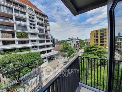 Stunning urban view from a modern balcony overlooking cityscape and greenery, perfect for city living.