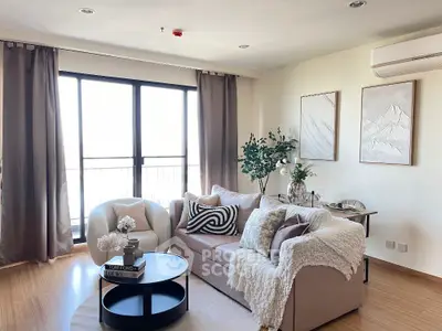 Stylish living room with cozy sofa, modern decor, and large windows offering natural light.