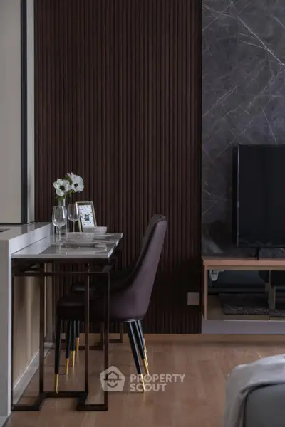 Modern living room with elegant decor and stylish furniture, featuring a sleek TV setup and a cozy dining area.