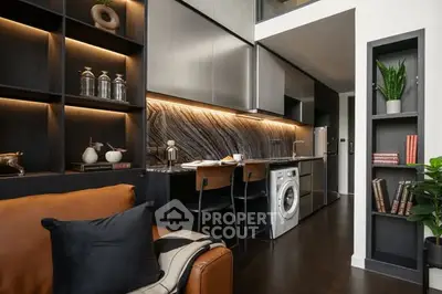 Modern living room with sleek kitchen, stylish decor, and integrated washing machine.