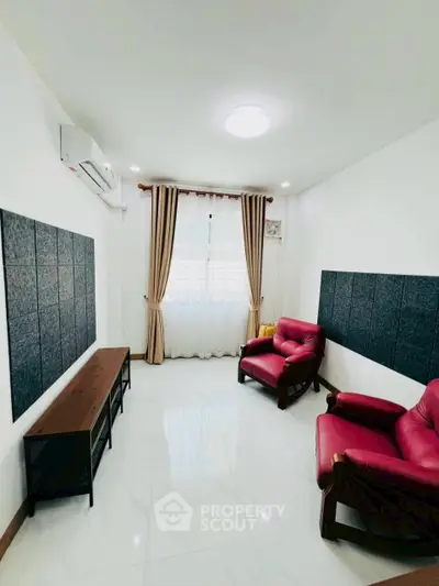 Bright living room with red armchairs and modern decor, perfect for relaxation.
