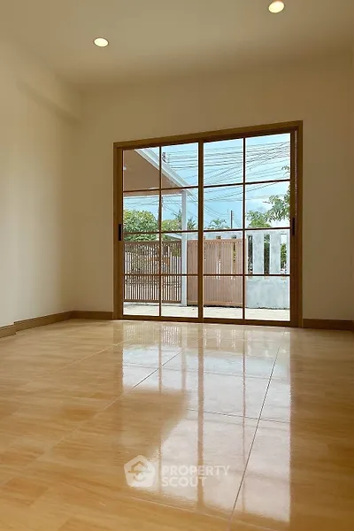 Spacious room with large sliding glass doors leading to a serene outdoor view.