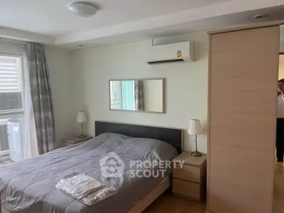 Cozy bedroom with modern decor, featuring a comfortable bed, air conditioning, and ample natural light.