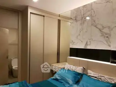 Modern bedroom with ensuite bathroom and stylish marble wall design.