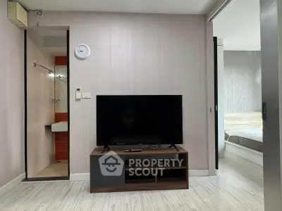 Modern living room with TV and adjacent bathroom in stylish apartment