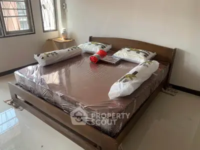 Spacious bedroom with large bed and natural light from windows, ideal for comfort and relaxation.