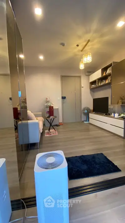 Modern living room with stylish decor and open layout, featuring a cozy seating area and elegant lighting.