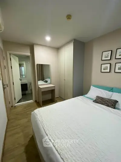 Cozy bedroom with modern decor and ensuite bathroom in stylish apartment.