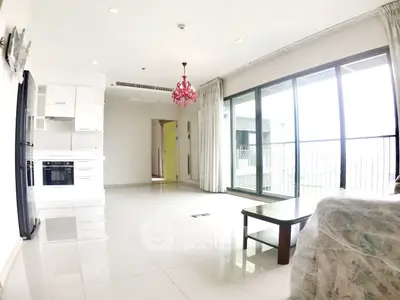 Spacious modern living room with open kitchen and large balcony access