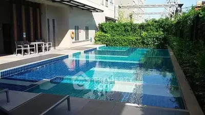 Luxurious outdoor pool area with modern design and lush greenery, perfect for relaxation and leisure.