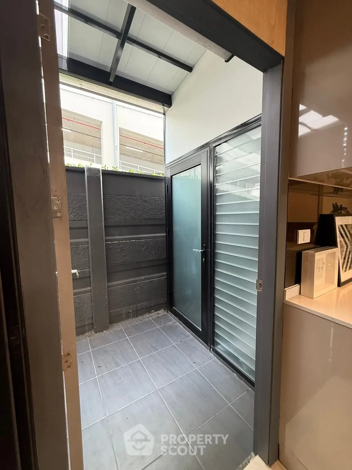 Modern small outdoor space with frosted glass door and sleek design