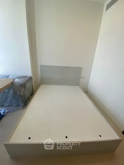 Spacious bedroom with modern bed frame and natural light, perfect for a cozy retreat.