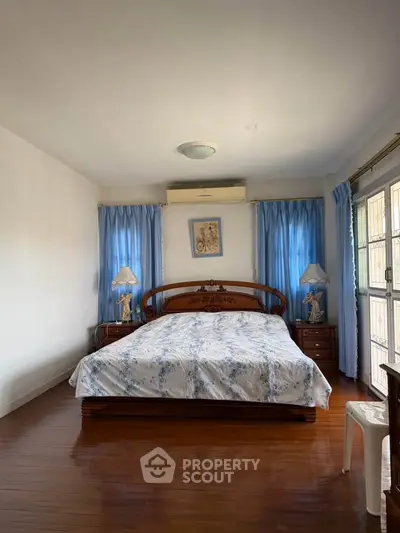 Cozy bedroom with wooden flooring and elegant decor