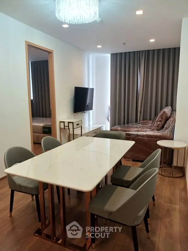 Modern dining area with elegant marble table and cozy seating in stylish apartment.