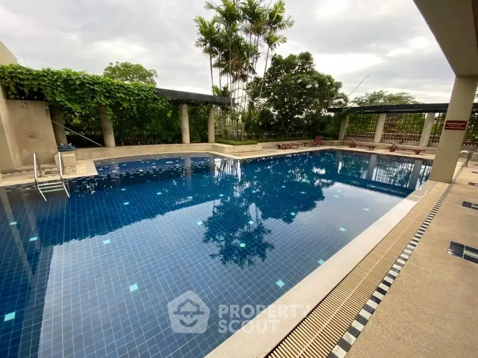 Luxurious outdoor swimming pool with lush greenery and serene ambiance, perfect for relaxation and leisure.