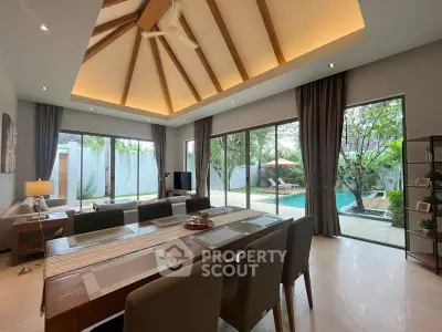 Luxurious open-plan living room with pool view and vaulted ceiling, perfect for modern living.