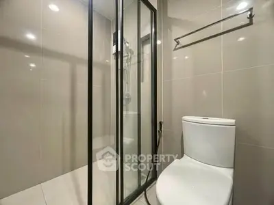 Modern bathroom with glass shower enclosure and sleek toilet design.