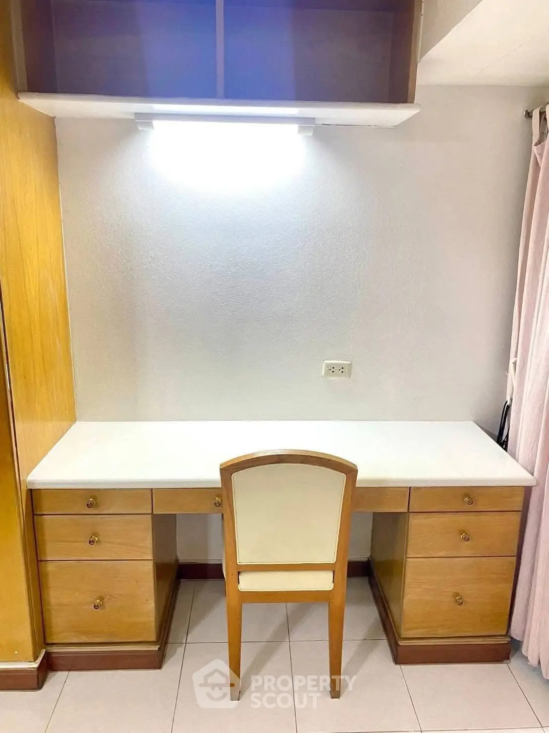 Spacious study area with elegant wooden desk and chair, perfect for productivity and organization.