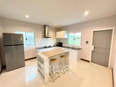 Modern kitchen with island, gas stove, and sleek appliances in a bright, open layout.