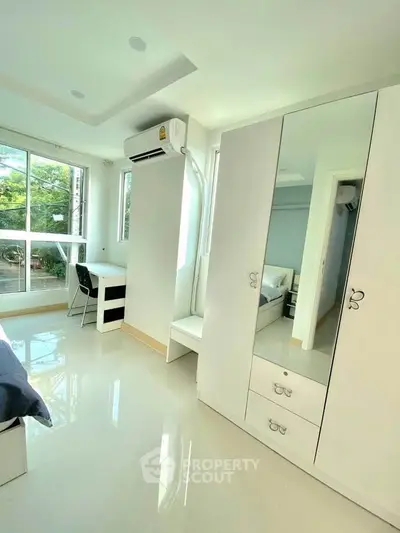 Bright and modern bedroom with large windows and sleek furniture