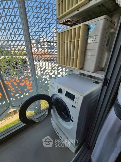 Compact balcony with washing machine and air conditioning units, ideal for urban living.