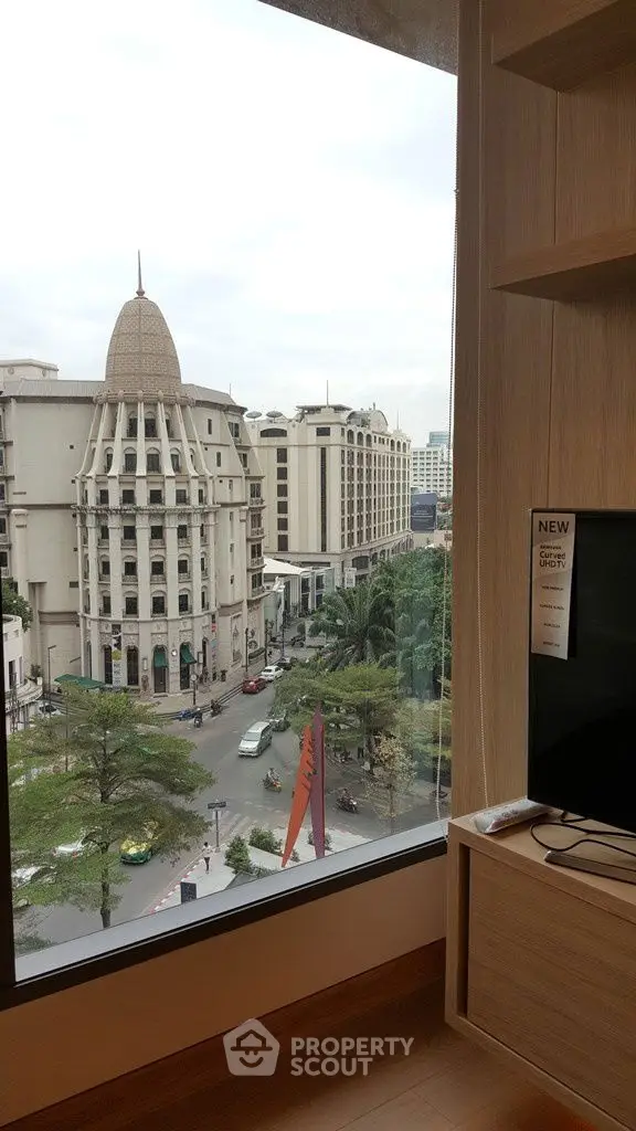 Stunning city view from modern apartment window, showcasing elegant architecture and vibrant urban life.