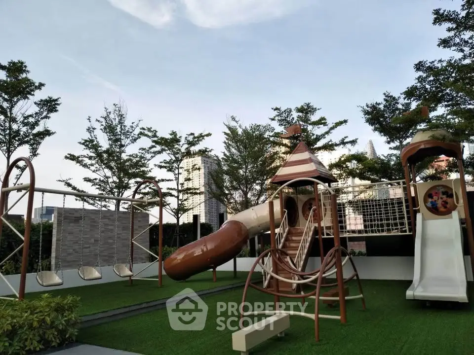 Modern playground area with swings and slides in a residential complex.