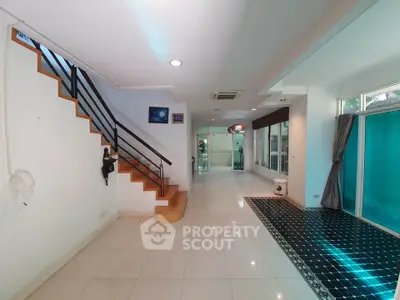 Spacious modern interior with staircase and large windows, ideal for stylish living.