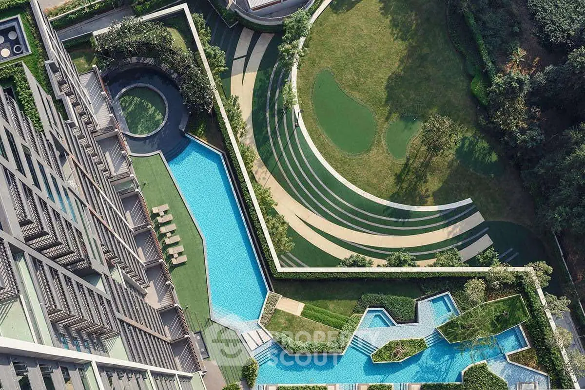 Luxurious aerial view of modern residential complex with stunning pool and landscaped gardens.