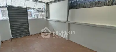 Spacious tiled storage area with secure metal gate and natural light