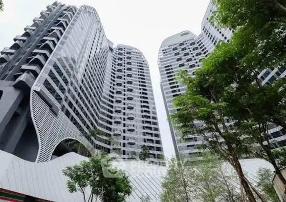 Stunning modern high-rise building with unique architectural design and lush greenery.