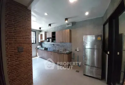 Modern kitchen with sleek cabinetry and stainless steel appliances in a stylish apartment.