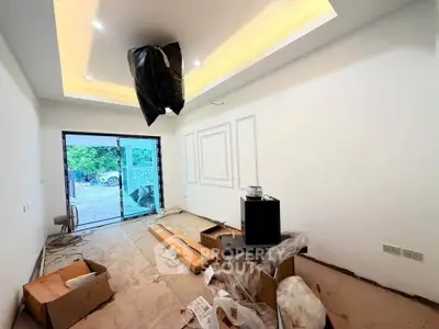 Spacious under-construction living room with modern ceiling lights and large glass doors.