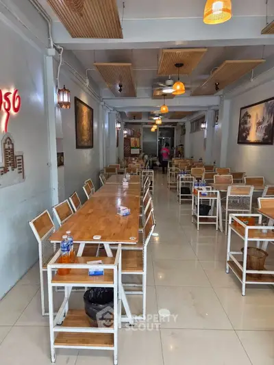 Charming cafe interior with wooden tables and chairs, warm lighting, and modern decor.