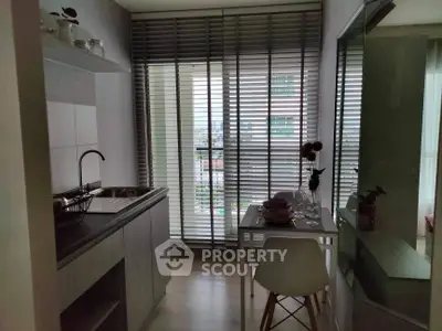 Modern kitchen with sleek design and city view through large windows.