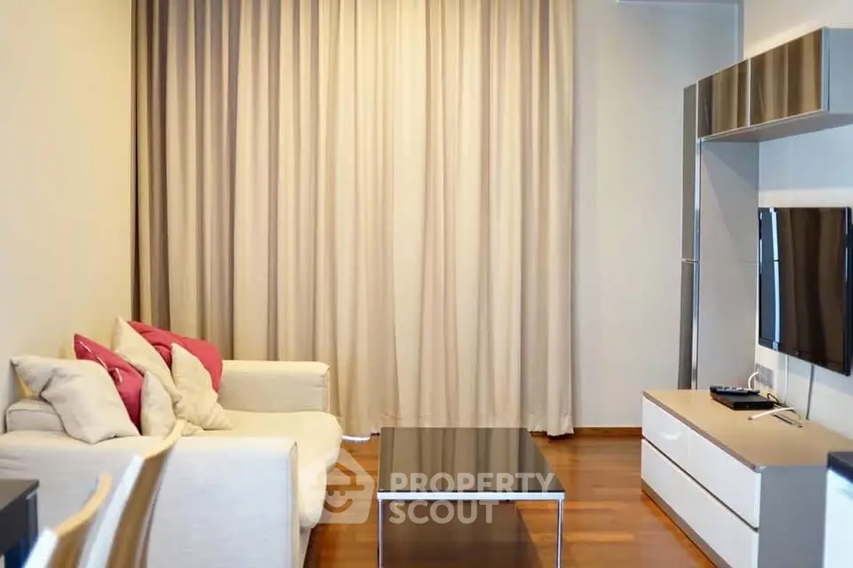 Modern living room with sleek furniture and wooden flooring, perfect for cozy gatherings.