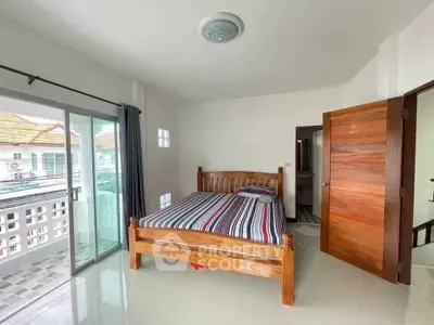 Spacious bedroom with wooden bed and balcony access in modern home