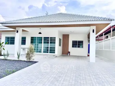 Modern single-story house with spacious driveway and elegant roof design