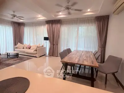 Spacious living room with elegant dining area and large windows for natural light.