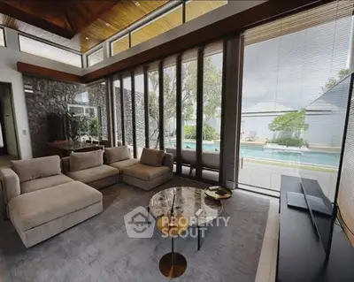 Luxurious living room with pool view, modern furniture, and floor-to-ceiling windows in a contemporary home.