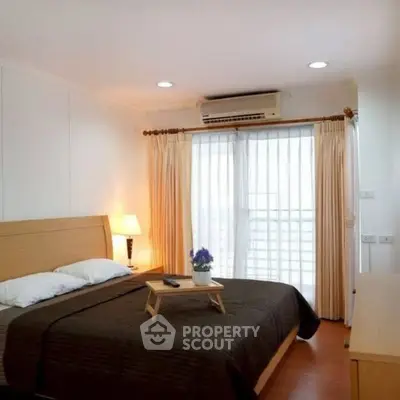 Cozy bedroom with natural light and modern decor, featuring a comfortable bed and elegant curtains.