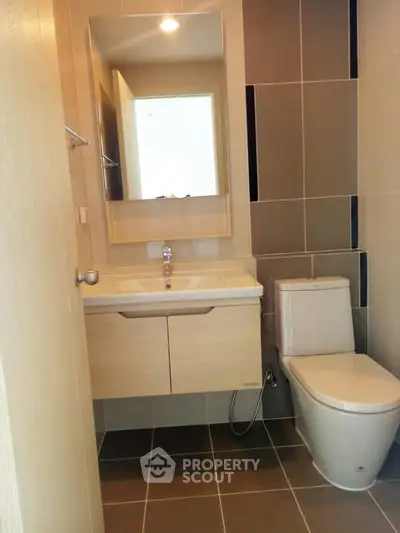 Modern bathroom with sleek fixtures and neutral tiles in a contemporary apartment.