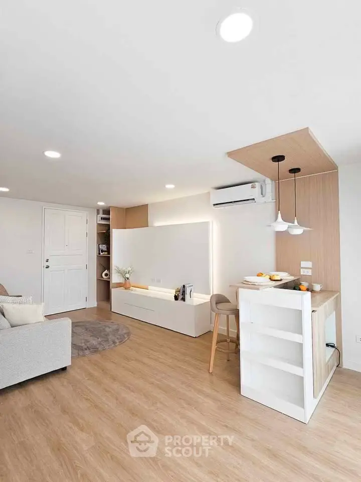 Modern living room with open kitchen, featuring sleek design and cozy ambiance.