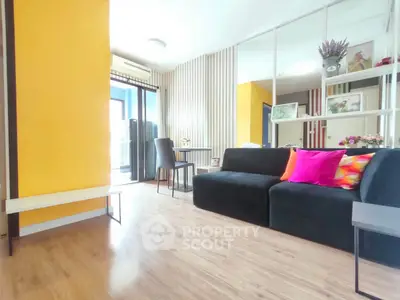 Modern living room with vibrant decor and balcony access, featuring sleek wooden flooring and stylish furnishings.