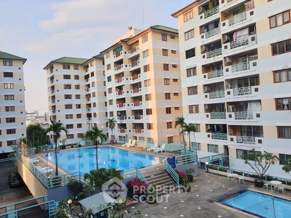 Spacious residential complex with pool and multiple apartment buildings, ideal for modern living.