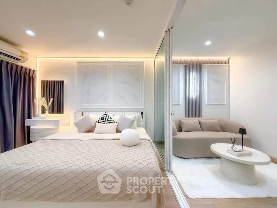 Modern bedroom with elegant decor and cozy seating area, featuring stylish lighting and neutral tones.