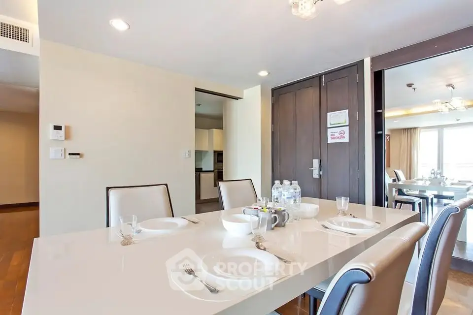 Modern dining area with elegant table setting in a bright apartment interior.