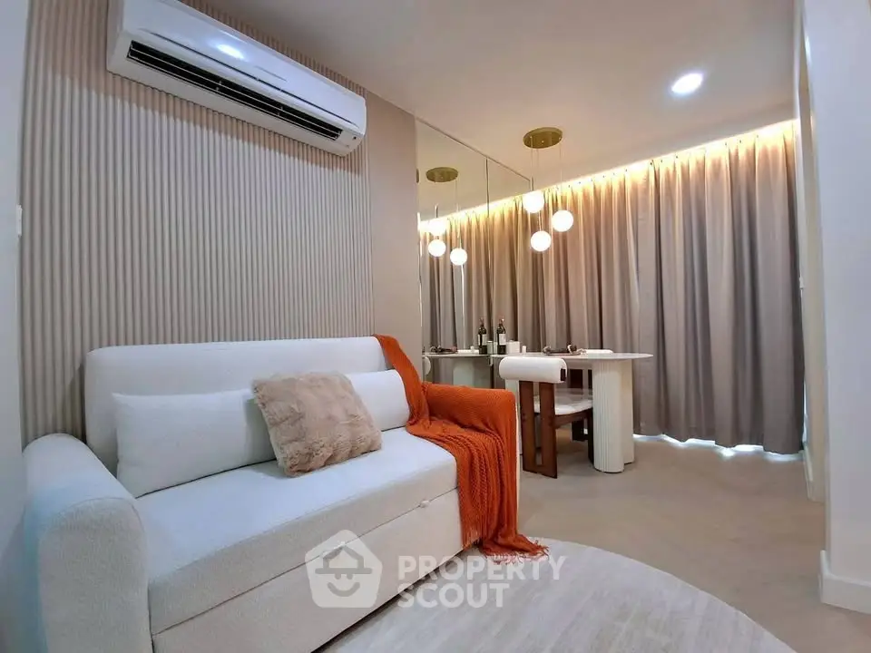 Modern living room with elegant decor and cozy ambiance, featuring a stylish sofa and dining area.