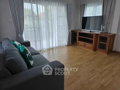 Spacious living room with modern decor and large windows for natural light.